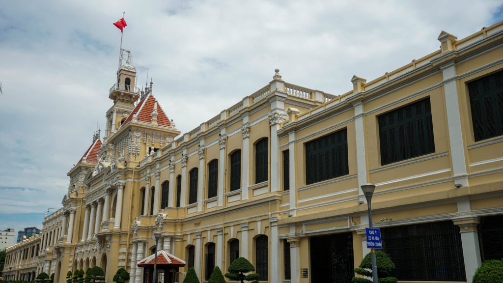 Photo du monuments construit dans le style francais derriere la statue de Ho Chi Minh lors de notre road trip a moto du sud au centre du Vietnam